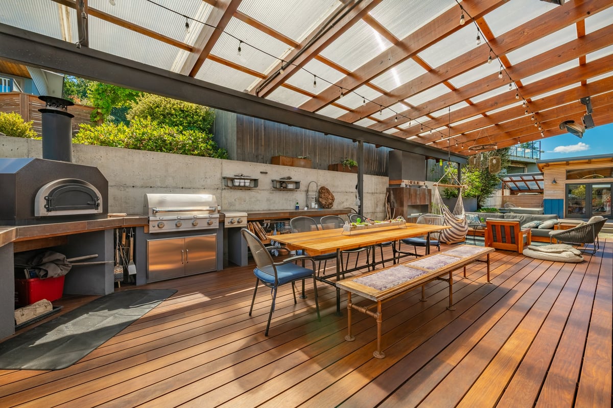 Beautiful outdoor kitchen and living space with pergola and outdoor seating